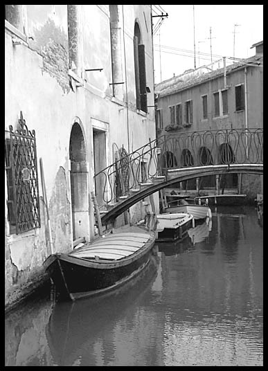 Boats lining the small canals of
                Venice