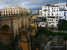 The whitewashed Hotel Don Miguel and the Puente Nuevo bridge, seen shrouded by storm clouds